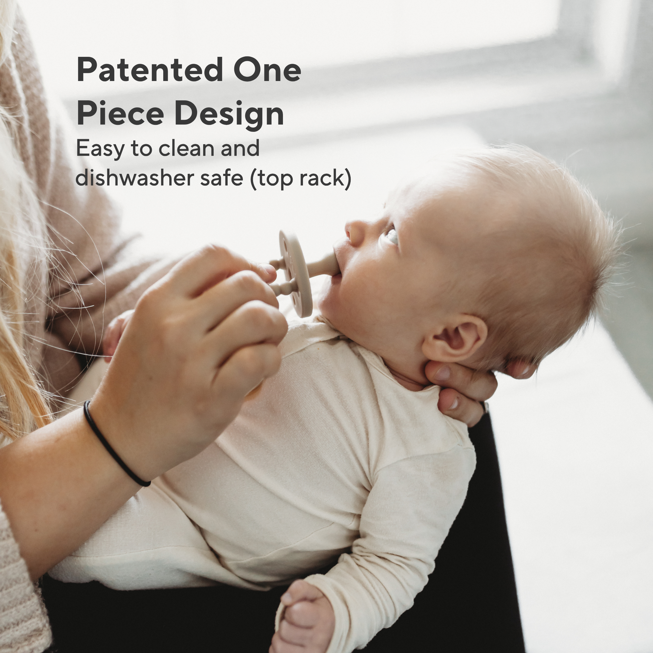 Baby holding a wooden teething ring with text about product features.