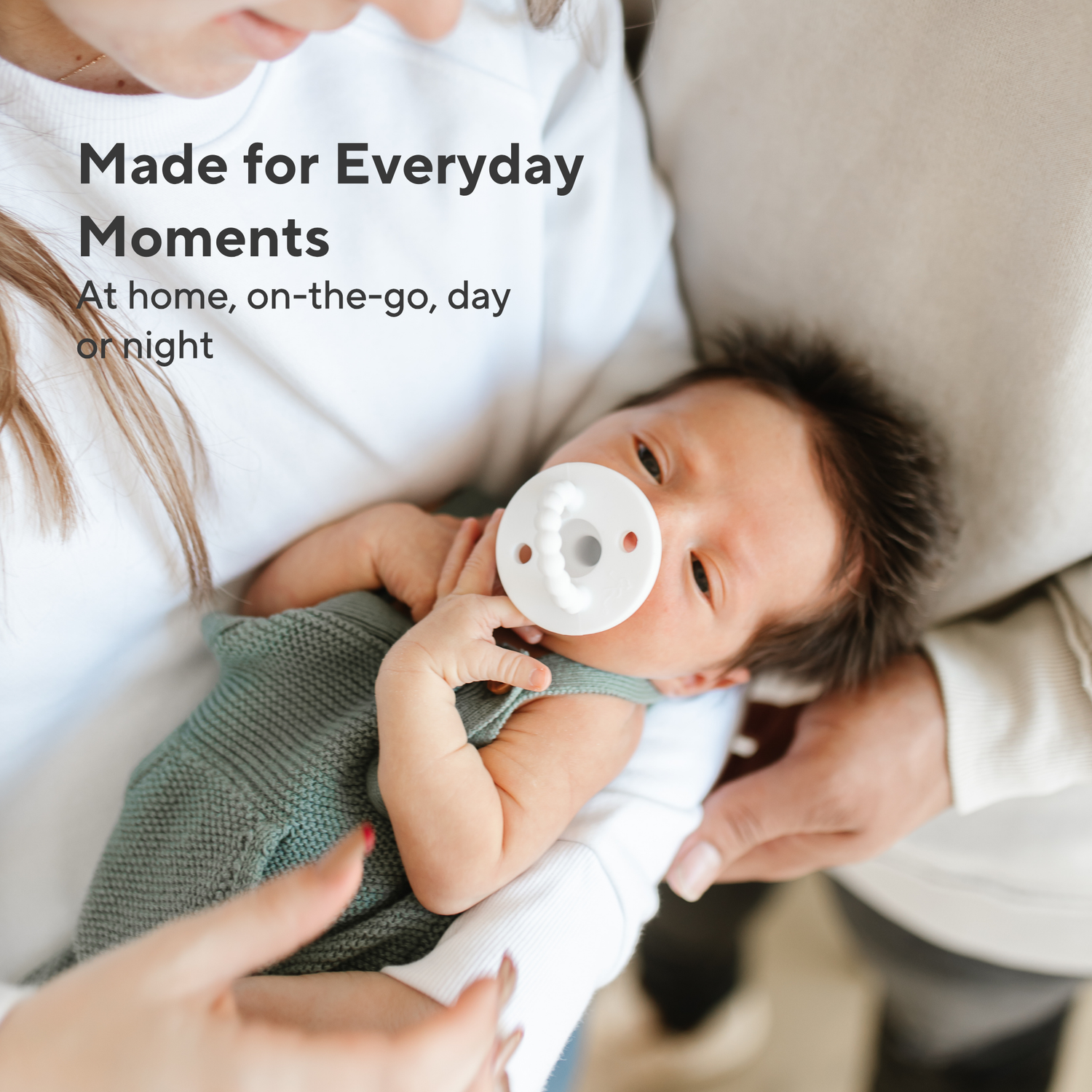 Baby holding a pacifier with text &