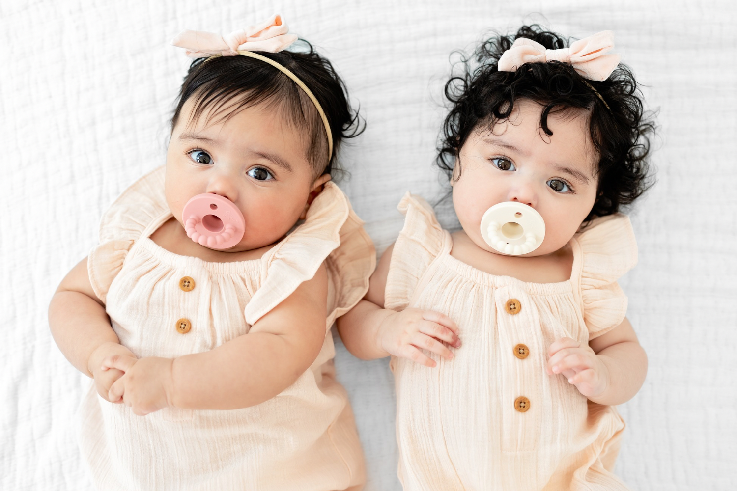 Baby girls with pacifiers