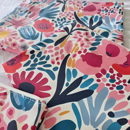Floral patterned fabric with pink, blue, and red colors on a white background