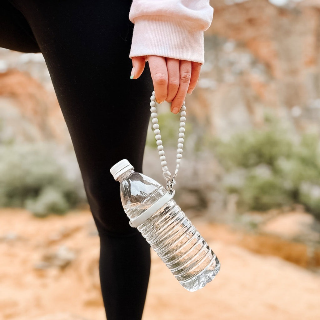 Girl holding the Slate Cutie Handle attached to a plastic water bottle.