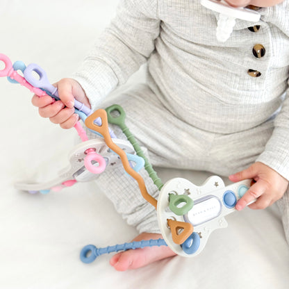 Child holding a colorful key-shaped toy on a white background