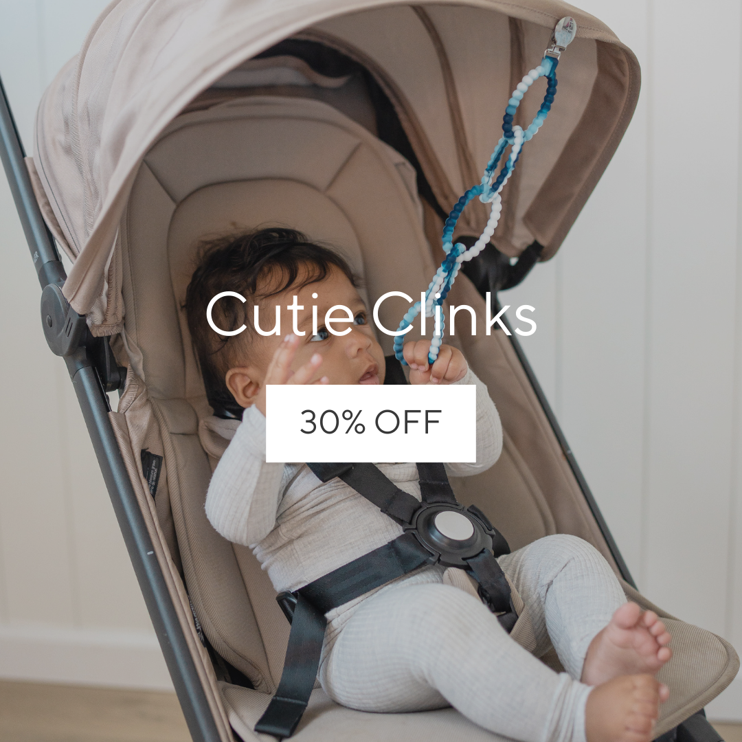 Baby in a stroller playing with Cutie Clinks.