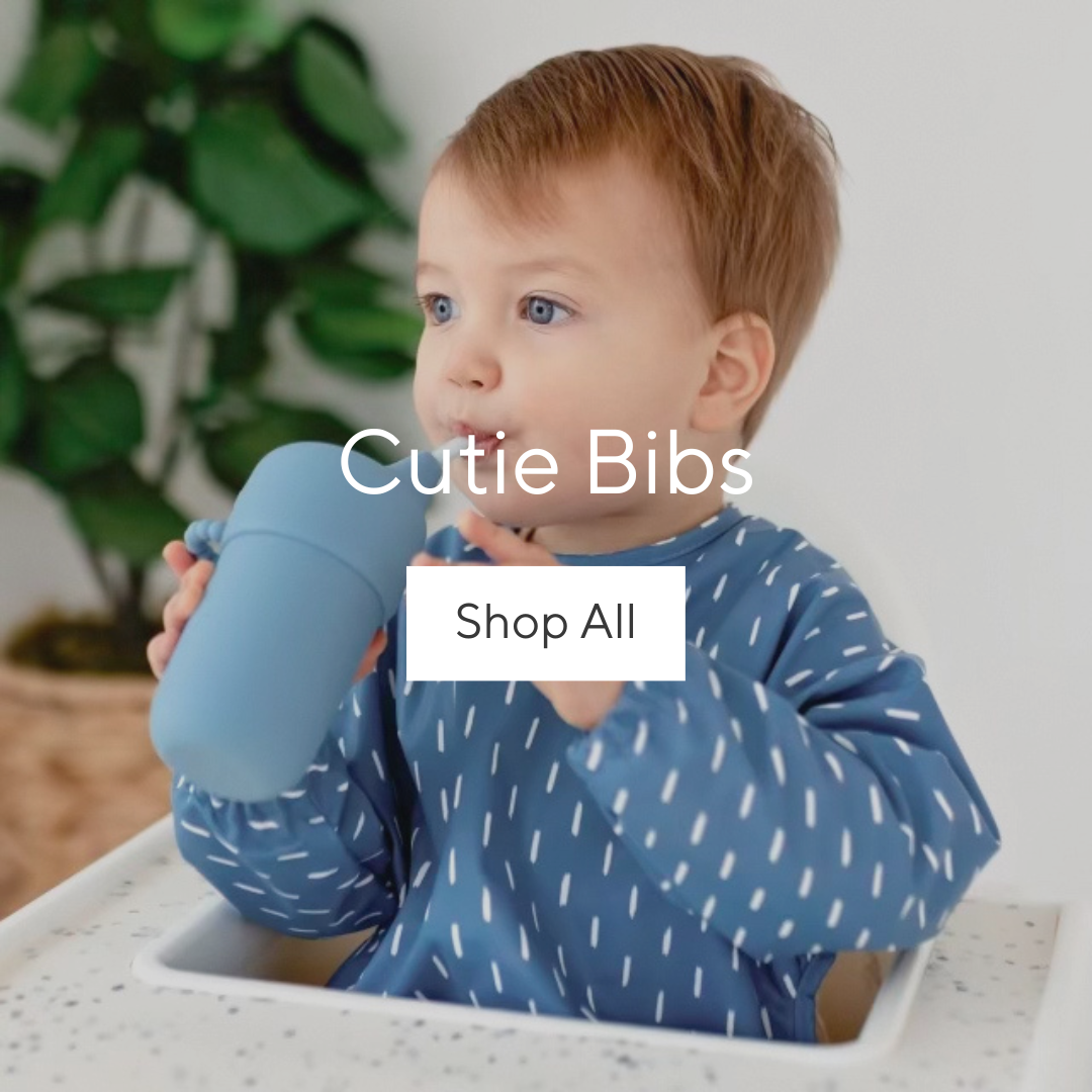 Baby boy wearing Cutie Bib drinking out of a Cutie Cup.