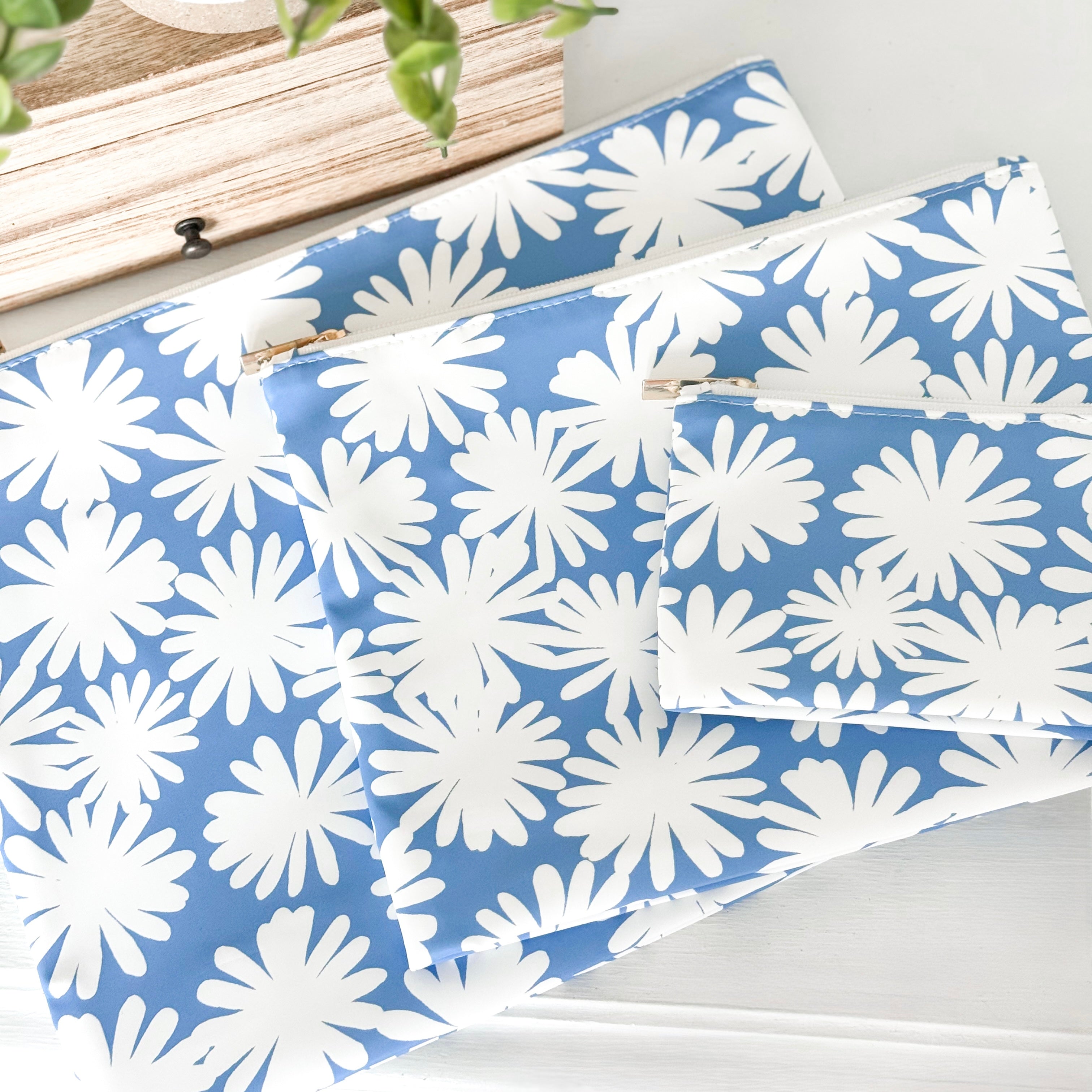 Blue and white floral patterned fabric on a white surface with a wooden frame in the background.