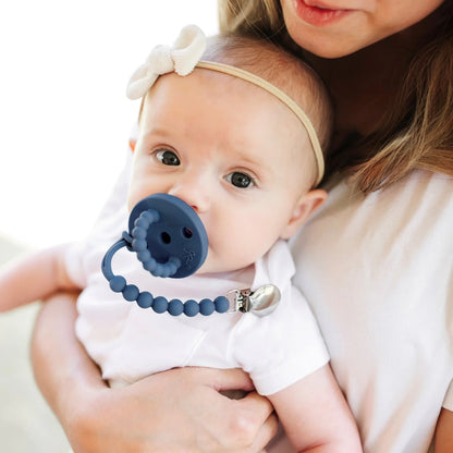 Baby wearing a pacifier and clip