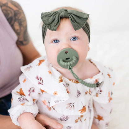 Baby wearing a pacifier and clip