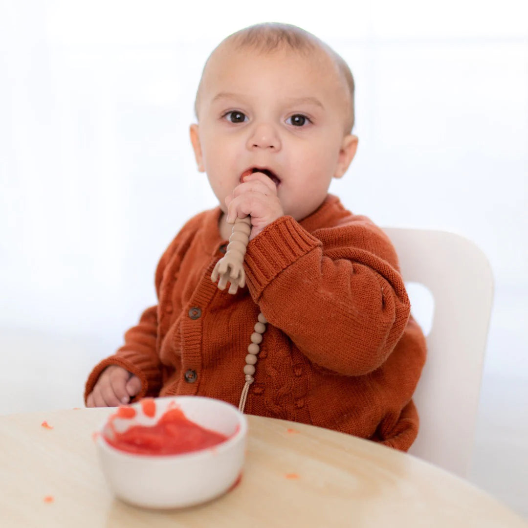 Baby eating at table with cutie tensils