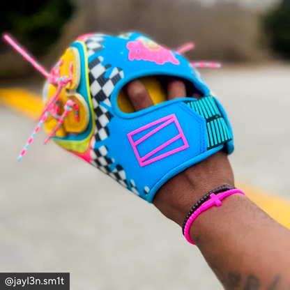 Colorful glove with checkered pattern and pink accents worn on a hand.