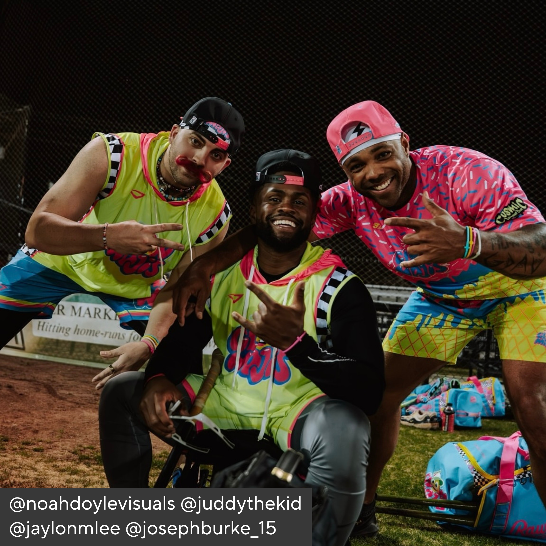 Three people in colorful outfits posing together on a sports field.