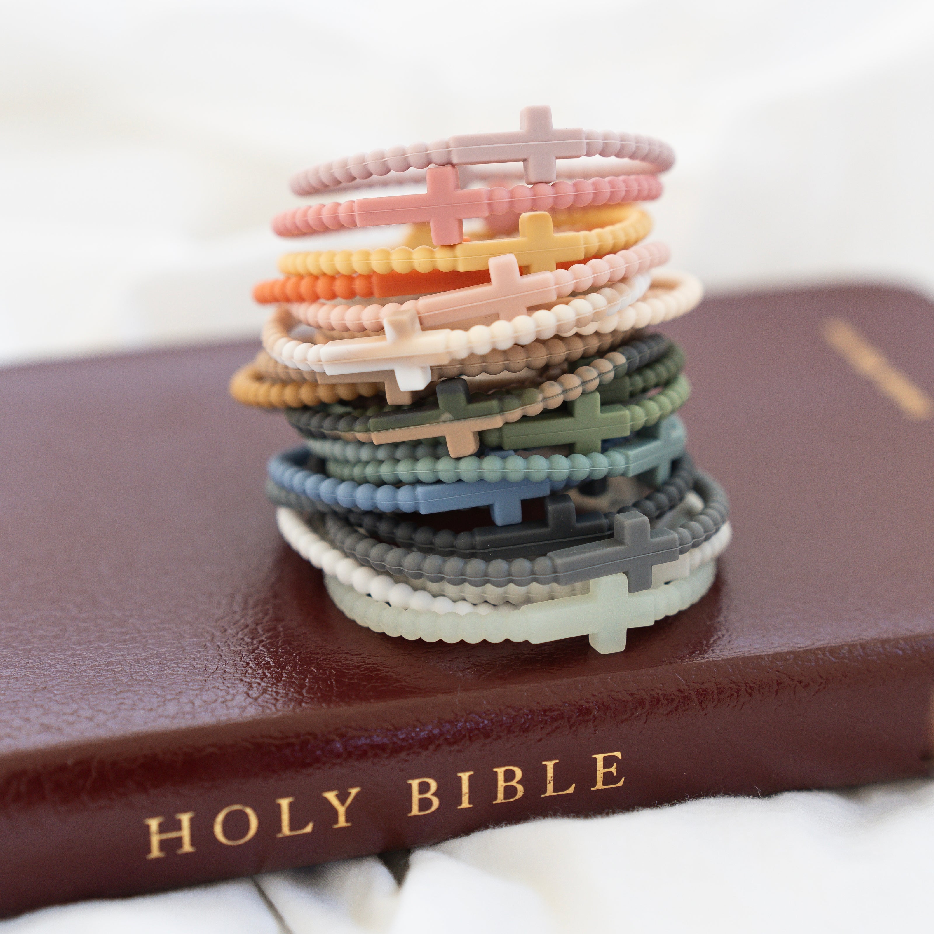 Jesus bracelets stacked on a Bible