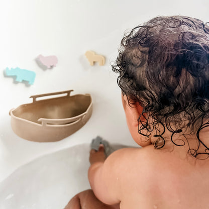 Baby in bath playing with Noah’s Ark toy
