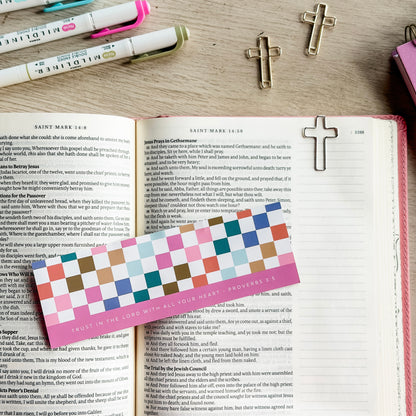 Open book with colorful bookmark and cross-shaped bookmarks on a wooden surface