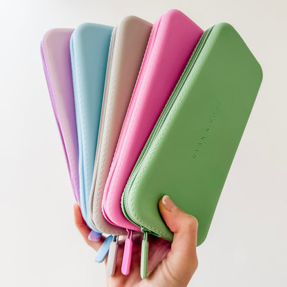 Set of colorful wallets held by a hand on a light background