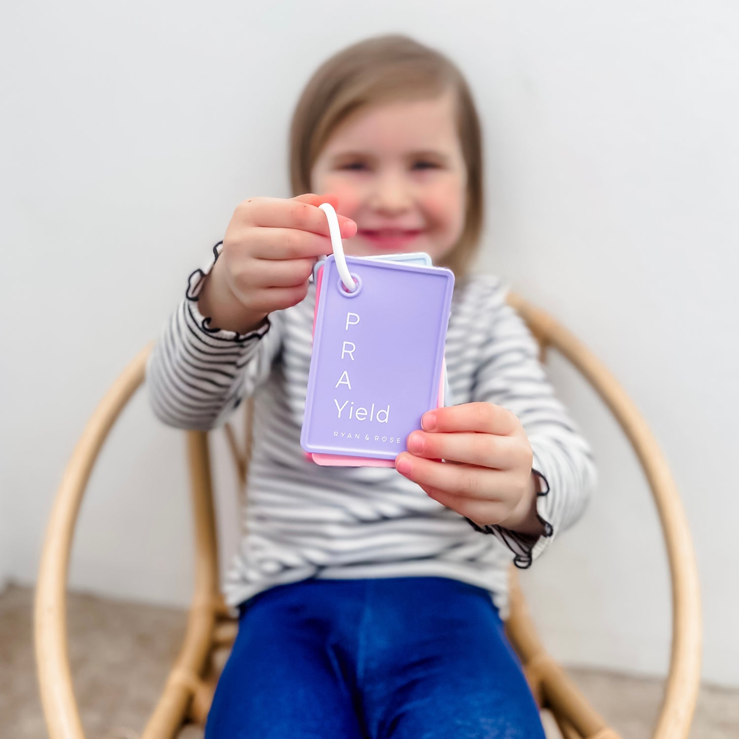 Child holding a purple card with &