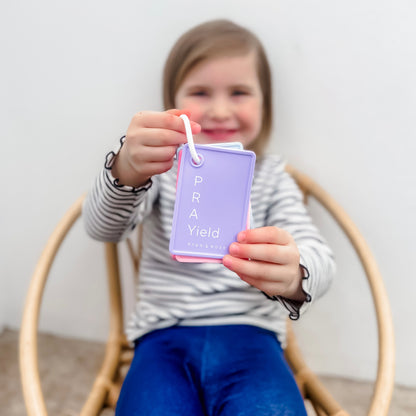 Child holding a purple card with &