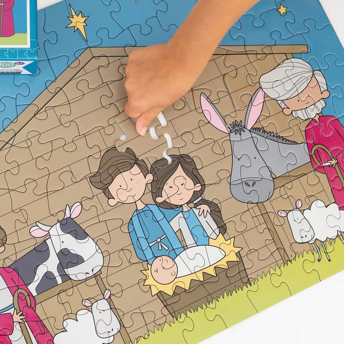 Children's Nativity scene puzzle with a hand placing a piece.