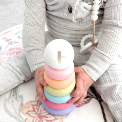 Child holding a colorful stacking toy with a soft background