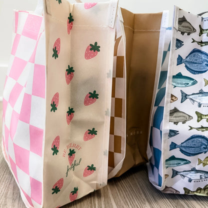 Three fabric bags with different patterns on a wooden surface.