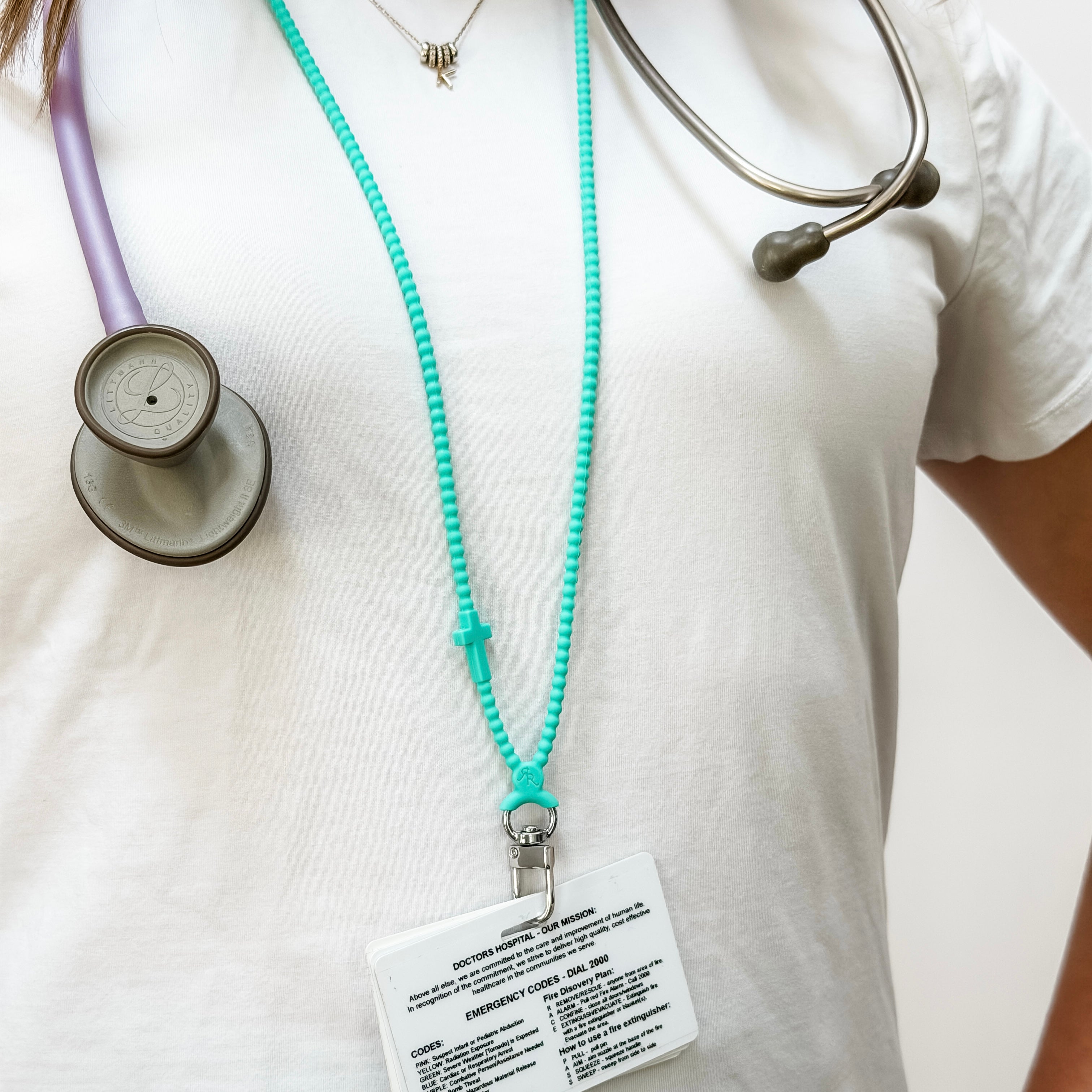 Person wearing a stethoscope with a turquoise lanyard and badge on a white background