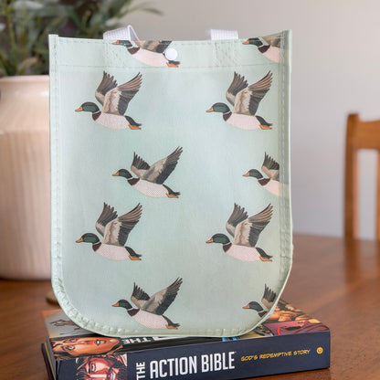 Reusable shopping bag with duck pattern on top of a book titled &