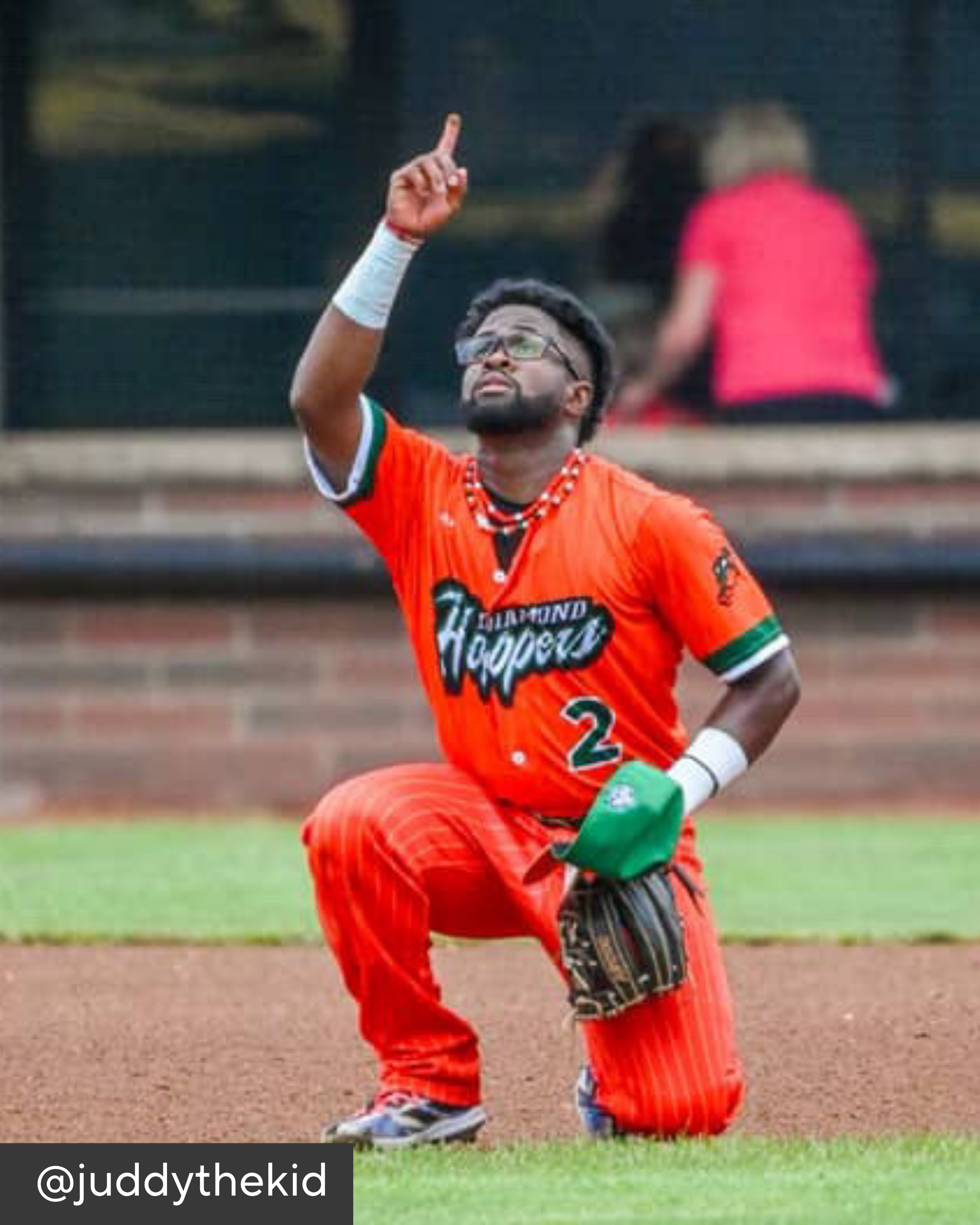 Baseball player in an orange uniform with 'Diamond Hoopers' on a baseball field.