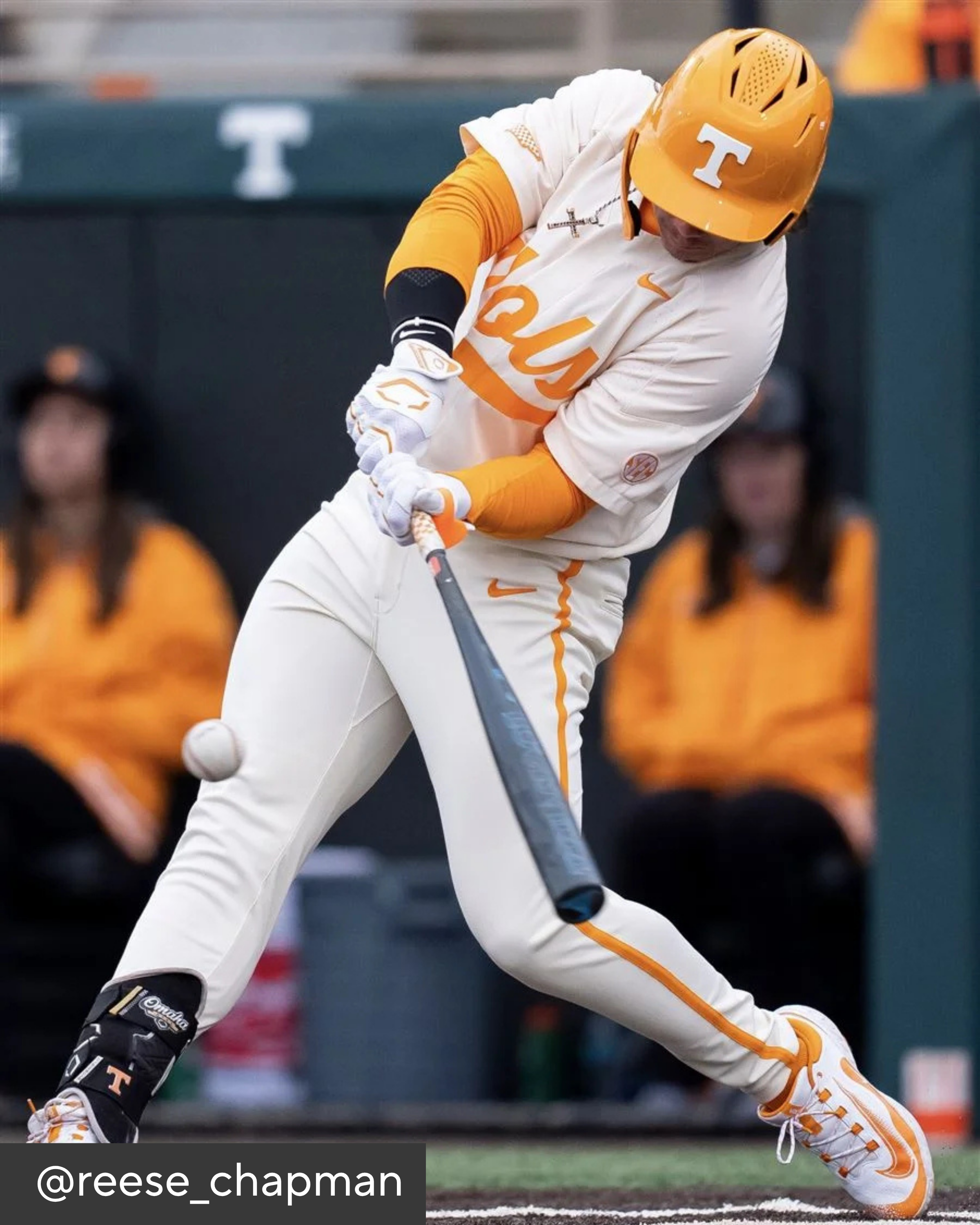 Baseball player in Tennessee uniform swinging a bat on a field