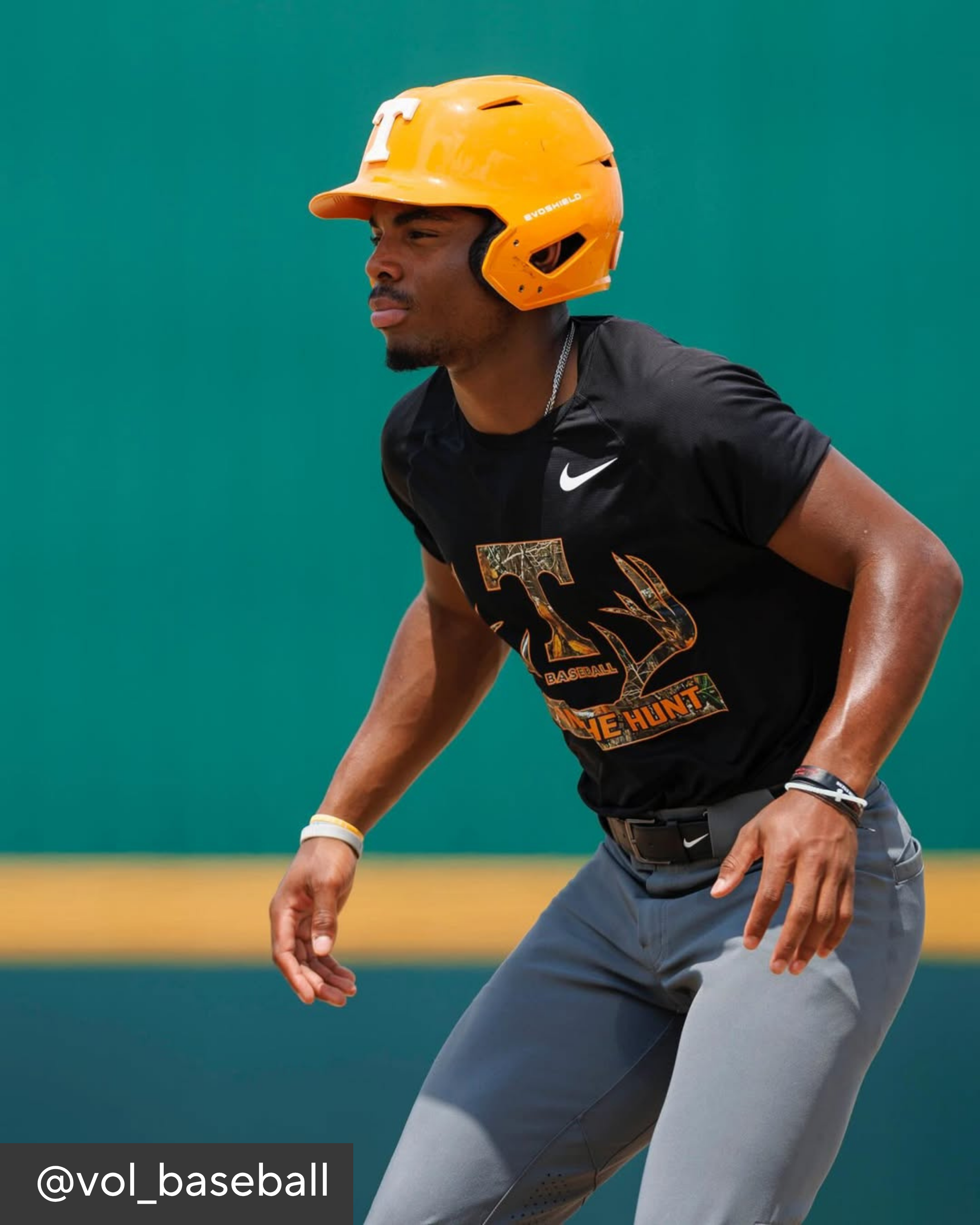 Baseball player in black jersey and yellow helmet on a field