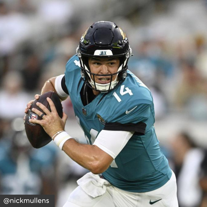 Football player in teal jersey with number 14 holding a football, wearing helmet with &