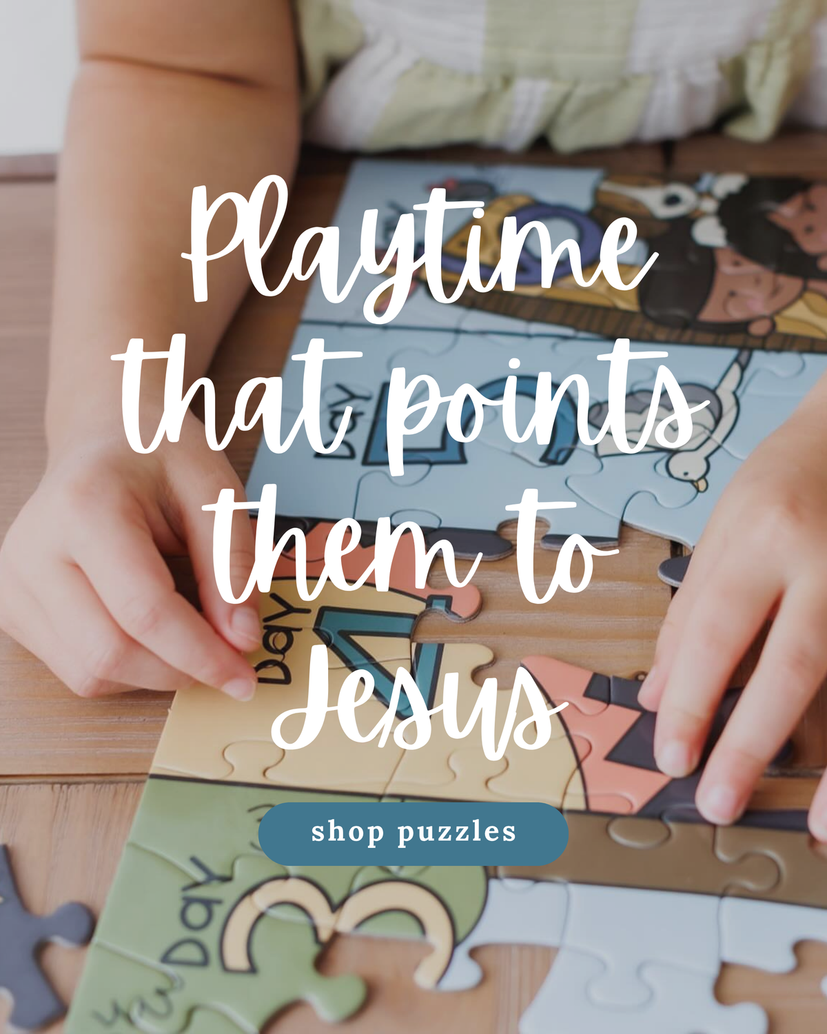 A child's hands are shown assembling a colorful children's jigsaw puzzle on a wooden table. Large white text overlays the center reading 'Playtime that points them to Jesus,' with a blue button below reading 'shop puzzles.