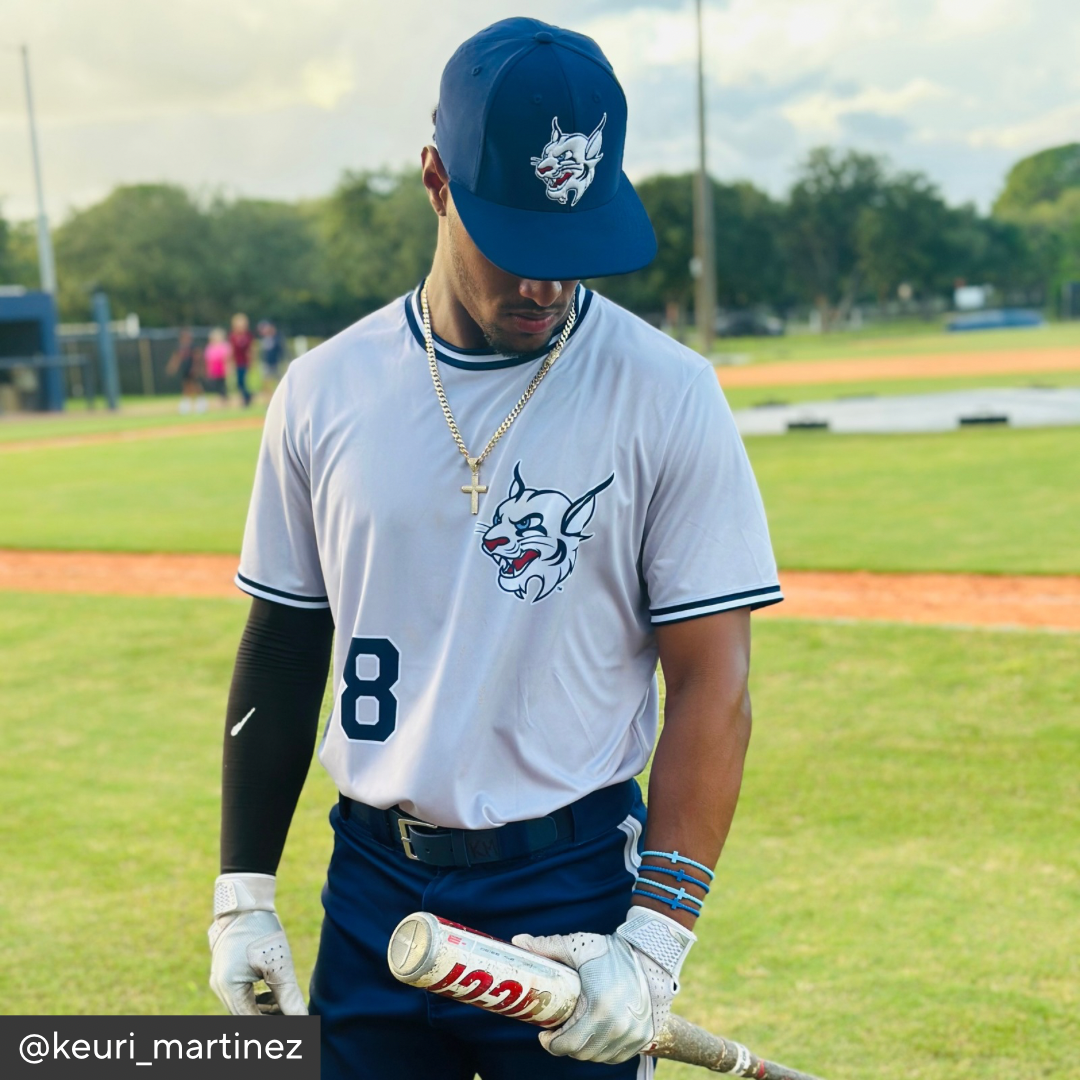 Baseball player in uniform with cap and bat on a field