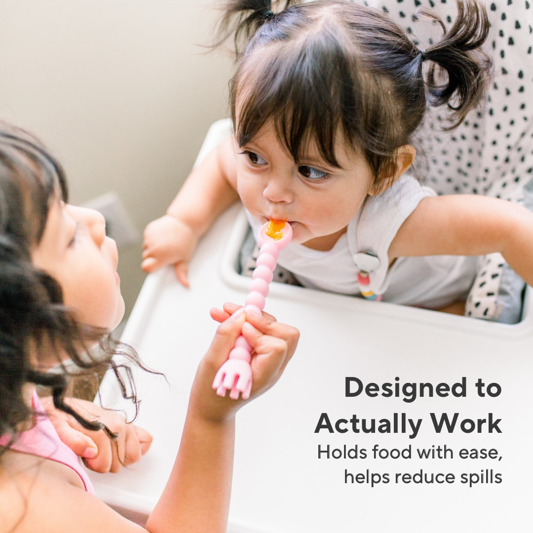 Two children using a pink spoon, with text indicating it helps reduce spills.