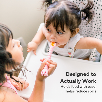 Two children using a pink spoon, with text indicating it helps reduce spills.