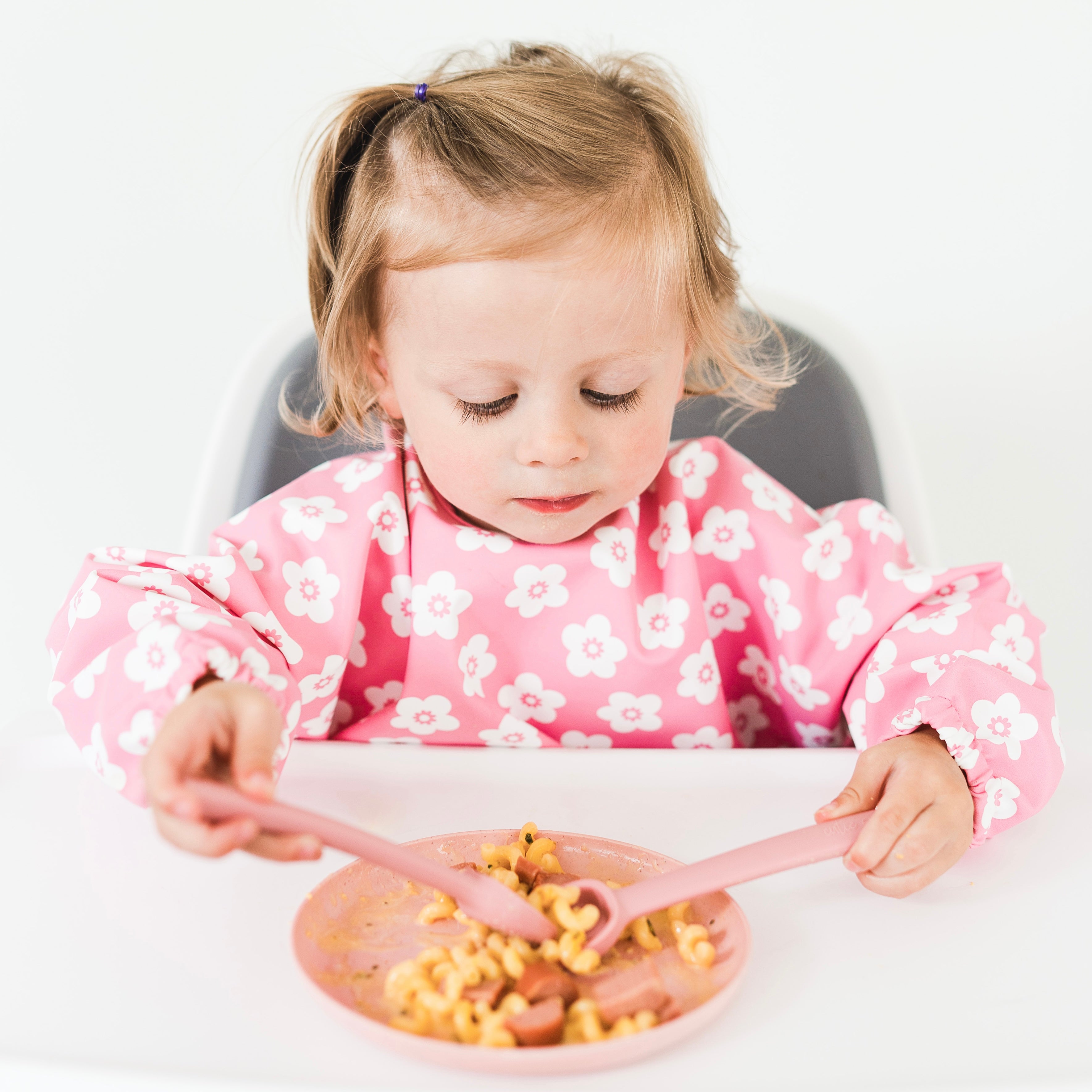 Toddler sitting in high chair eating with the Cutie Spoovel.