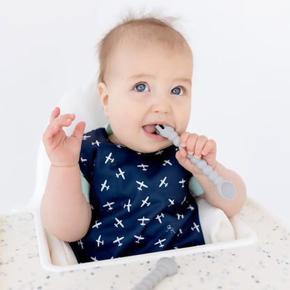 Baby sitting in high chair using Cutie Tensils.