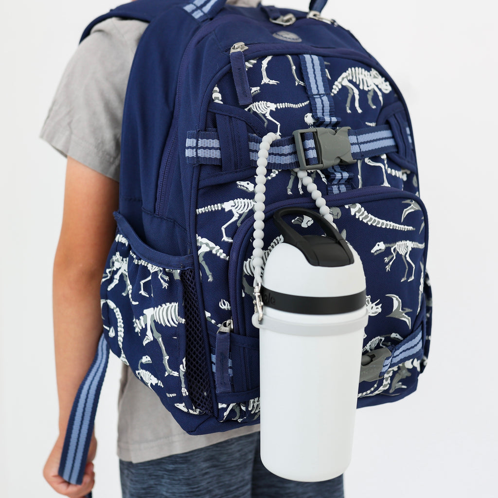 Boy wearing a backpack with Slate Cutie Handle attached holding a water bottle.