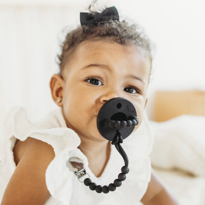 Baby girl wearing a Black Cutie PAT and Judy Cutie Clip.