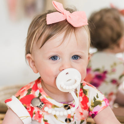 Baby girl wearing a White Cutie PAT and Judy Cutie Clip.