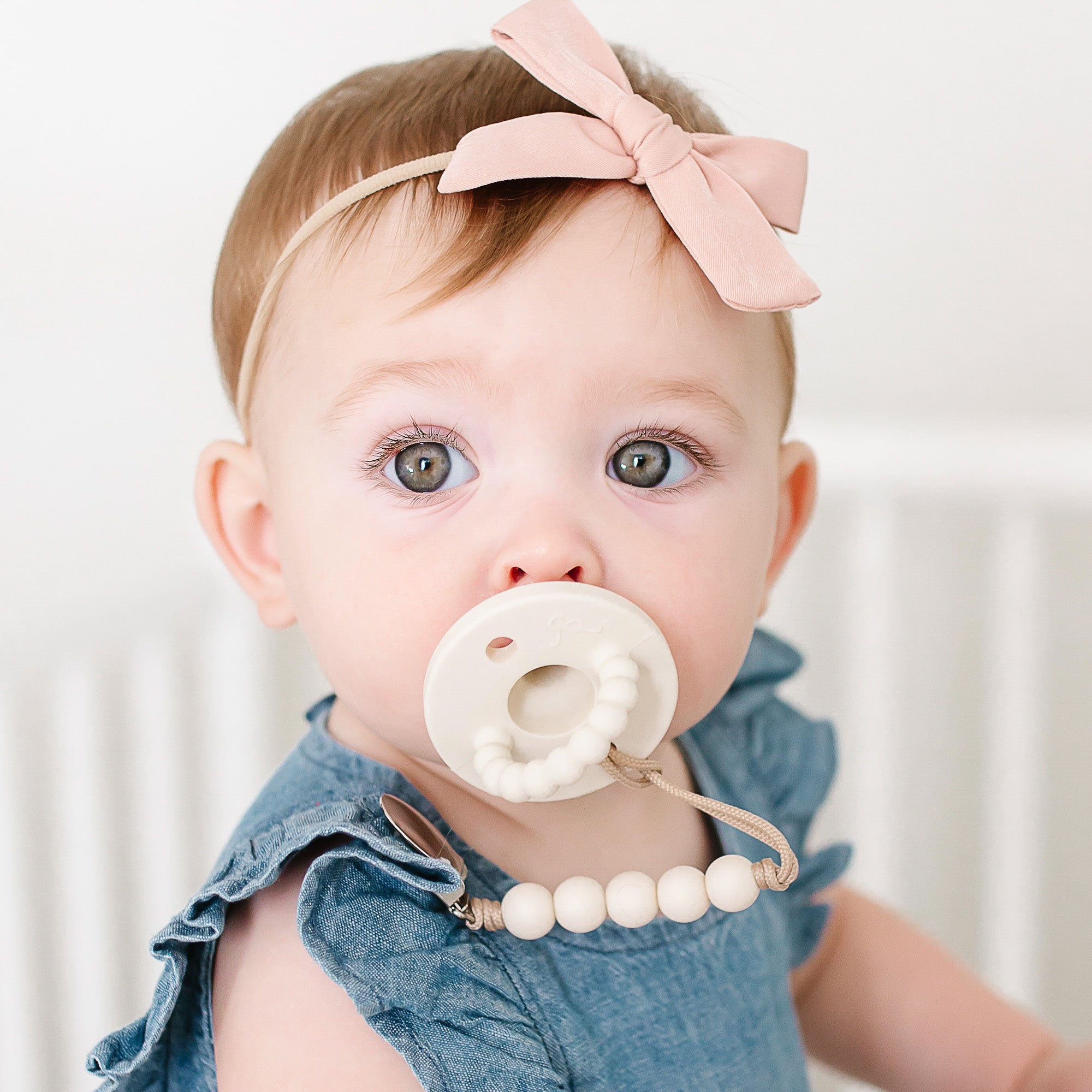 Baby girl wearing an Ivory Cutie PAT and Quinn Cutie Clip.