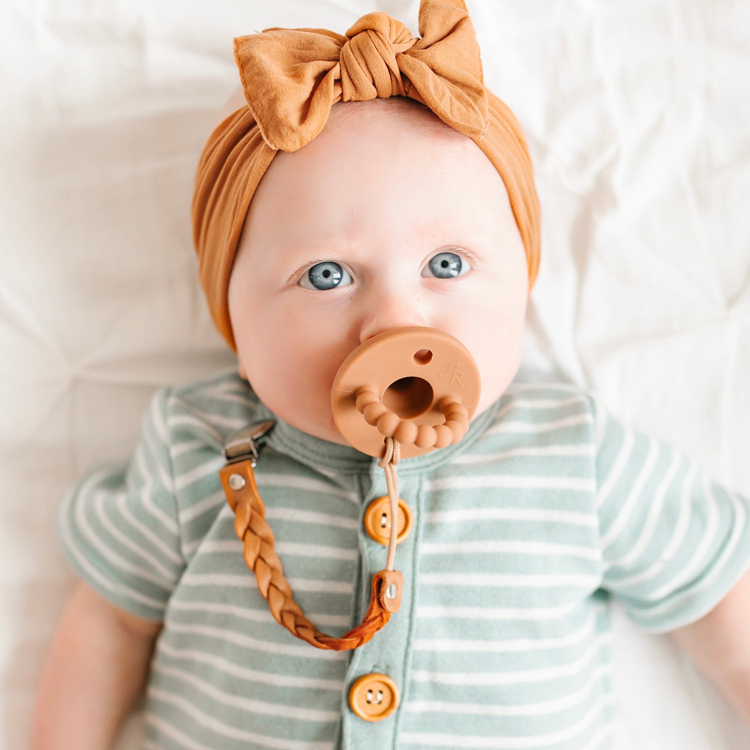 Baby girl wearing an Almond Cutie PAT and Lotus Cutie Clip.