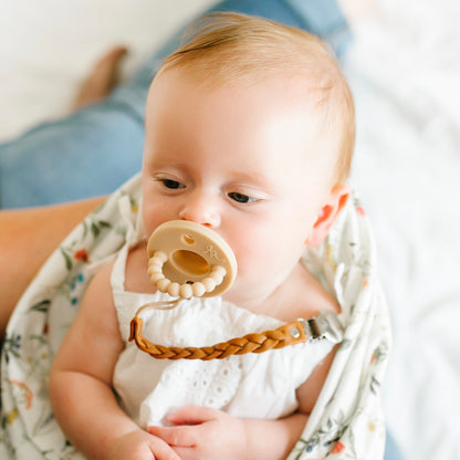 Baby girl wearing a Tan Cutie PAT and Lotus Cutie Clip.