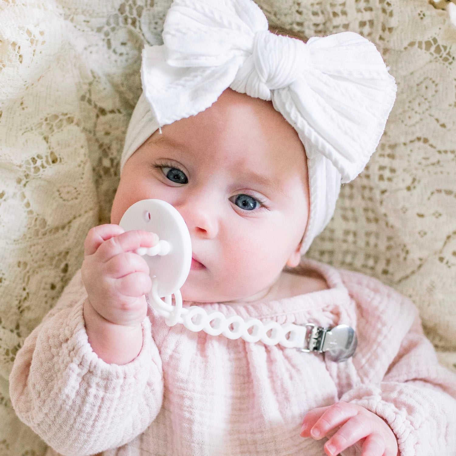 Baby girl wearing a White Cutie PAT and Hart Cutie Clip.