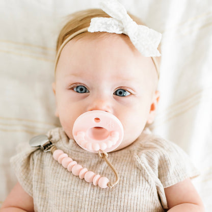 Baby girl using a Pink Cutie PAT and Olivia Cutie Clip.