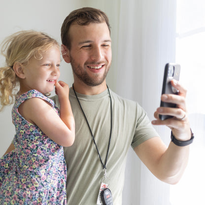 Dad holding his daughter wearing a Cutie Lanyard attached to his keys.