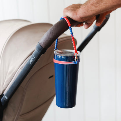 America Cutie Handle attached to a stroller handle holding a water bottle.