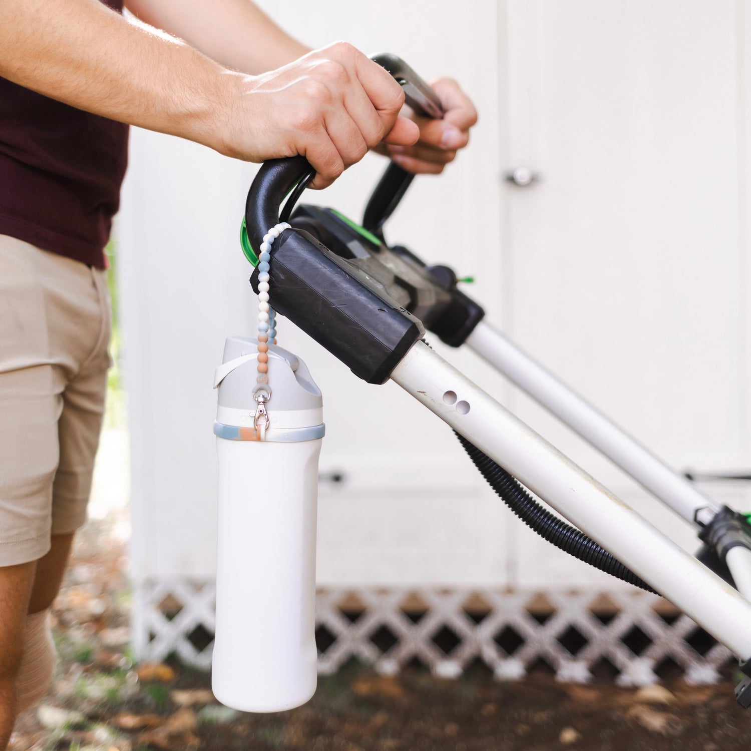 Cutie Handle attached to a lawn mower holding a water bottle.