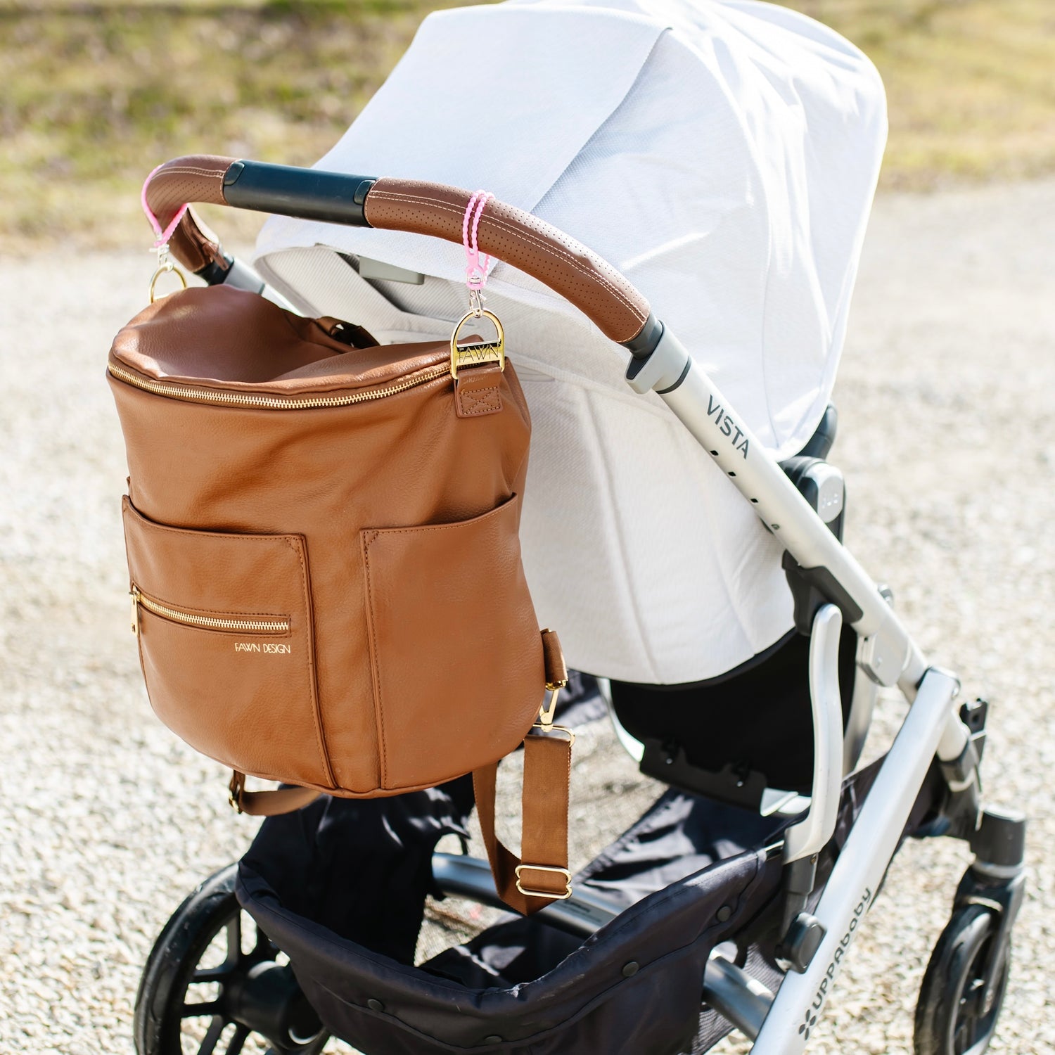 Cutie Loops holding a diaper bag on a stroller handle.