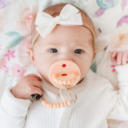 Baby girl wearing a Peach Cutie PAT and Luna Cutie Clip.